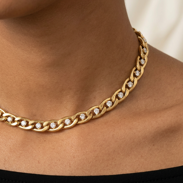 Close-up of gold links and crystal details on a brown-skinned model