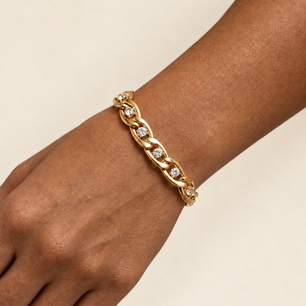 Gold bracelet on a brown-skinned model against ivory
