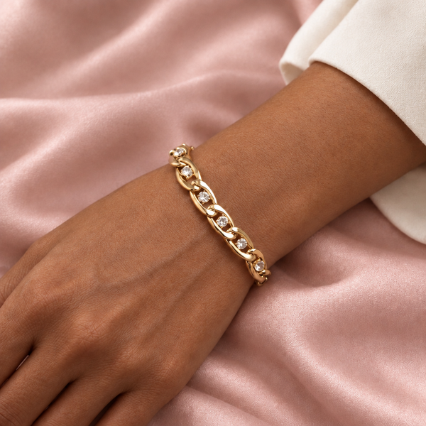 Gold bracelet on a brown-skinned model styled with blush silk