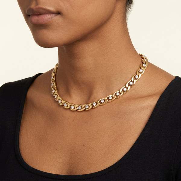 Three-quarter view of the gold crystal choker on a brown-skinned model